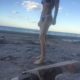 a picture of a woman showing her toned abs outside the beach