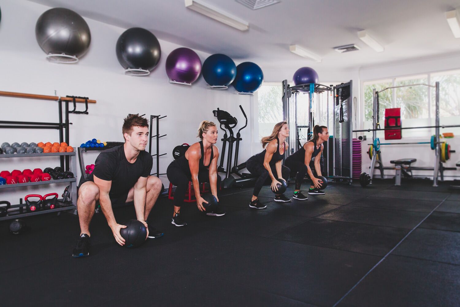 HIIT class. Big movements. Short intervals. Go hard a group of fitness enthusiasts building strength through workouts in a gym
