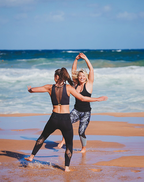 161023-perfect-fit-trainers-newport-beach-486 two women happily dancing at the beach