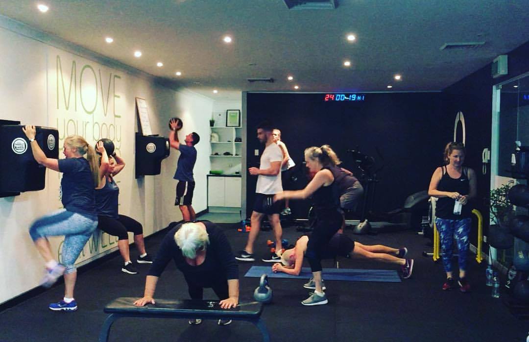 Open HIIT Circuit at Perfect Fit a group of fitness enthusiasts building strength through workouts in a gym