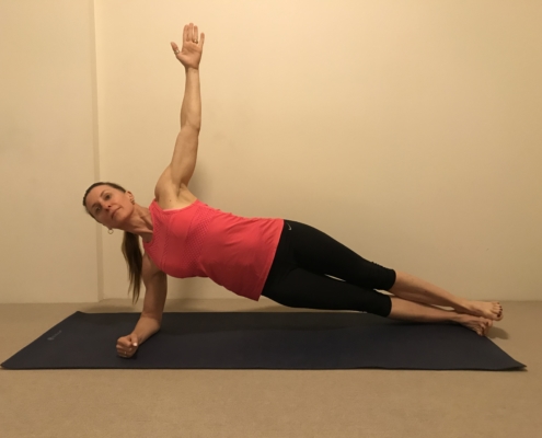 3B a woman doing a side plank on a yoga mat