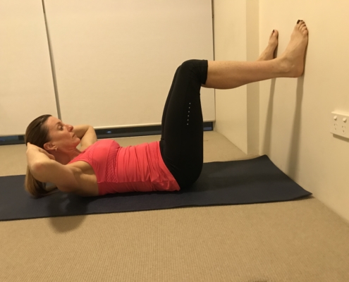 4C a picture of woman lying on her back with her feet on the wall