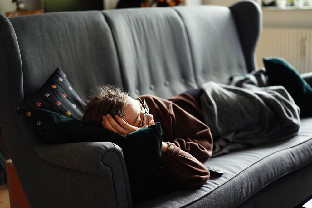 a picture of a woman with eyeglasses lying on a couch