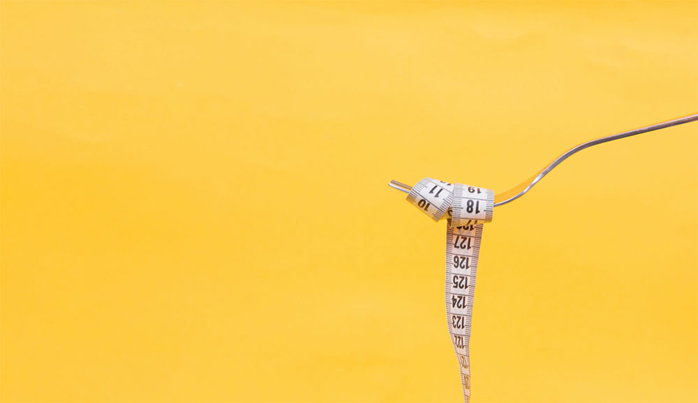 a picture of a fork with a tape measure rolled on it