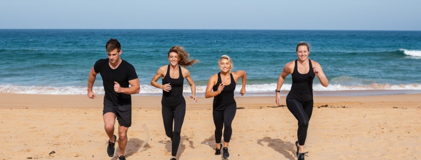 a group of people running happily at the beach