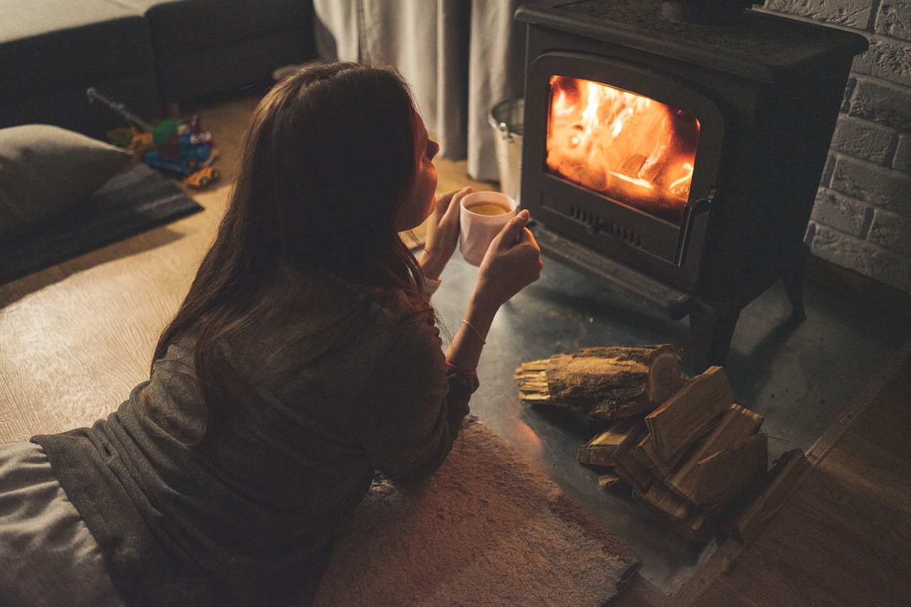 Preventing Winter Weight Gain a lady lying on her stomach and holding a cup in front of a fireplace